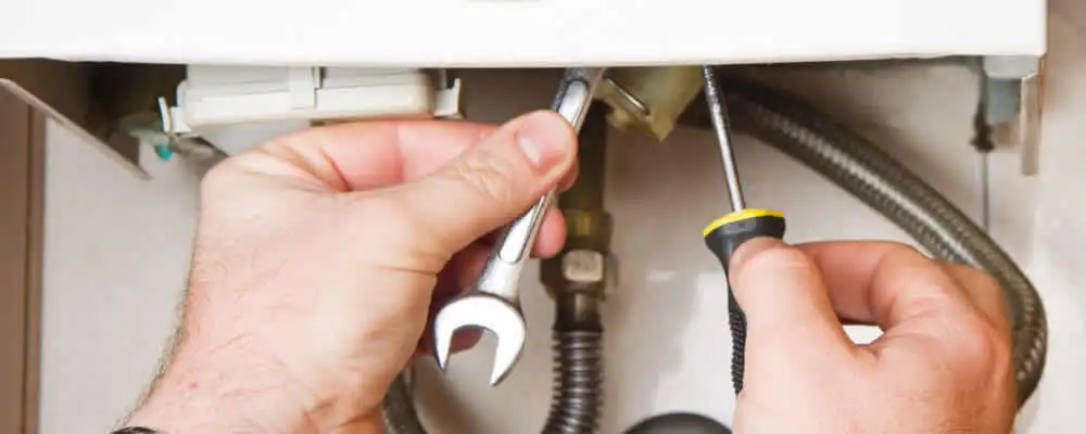 Boiler repair technician tightening pipe fittings and connections in Nashville, TN