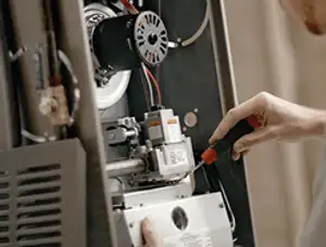 Furnace repair technician inspecting internal components and wiring in Nashville, TN