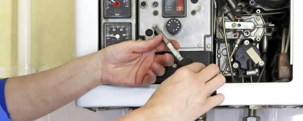 Heating repair technician adjusting boiler controls and components in Nashville, TN