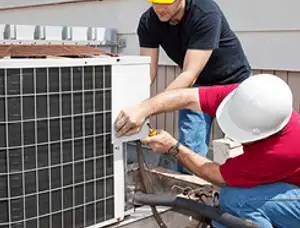 HVAC technicians repairing an outdoor AC unit on a rooftop in Nashville, TN