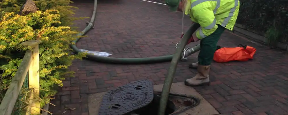 Septic tank cleaning technician servicing a septic tank with a vacuum hose in Nashville, TN