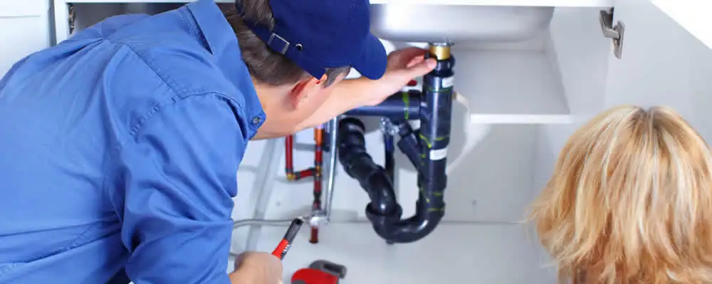 Plumber repairing under-sink drain pipes and fittings in Nashville, TN